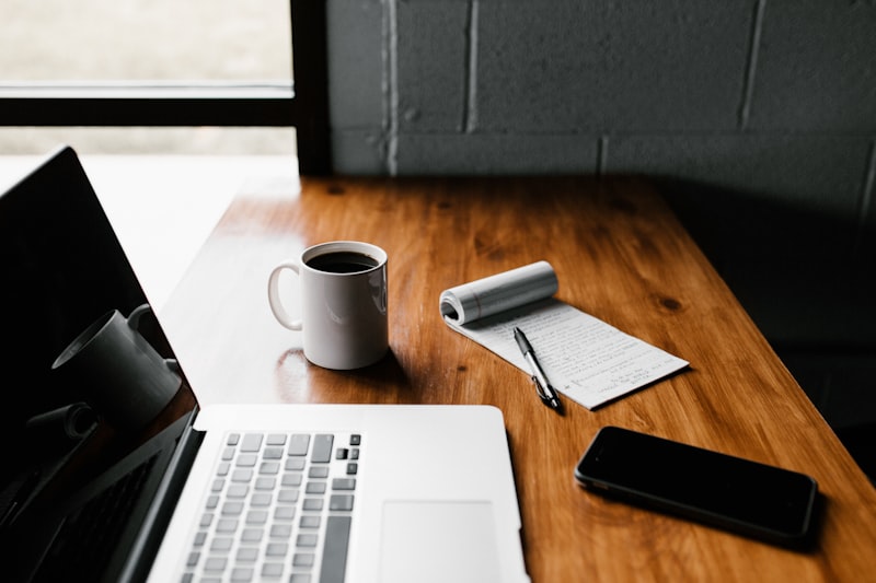 Content strategist working on a laptop with notes and planning documents